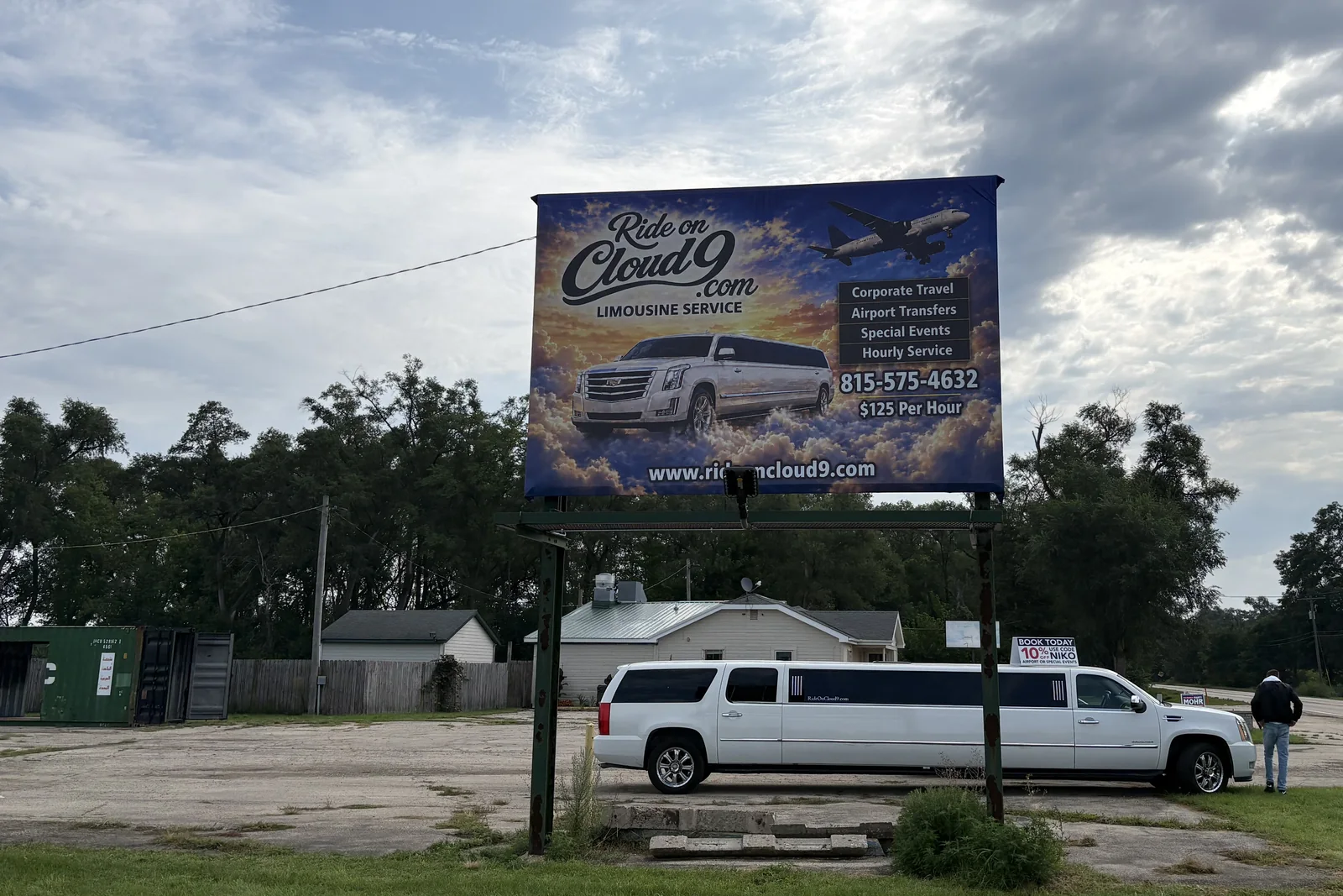 The Ride on Cloud 9 billboard on the highway in Huntley, with the stretch limousine parked below it