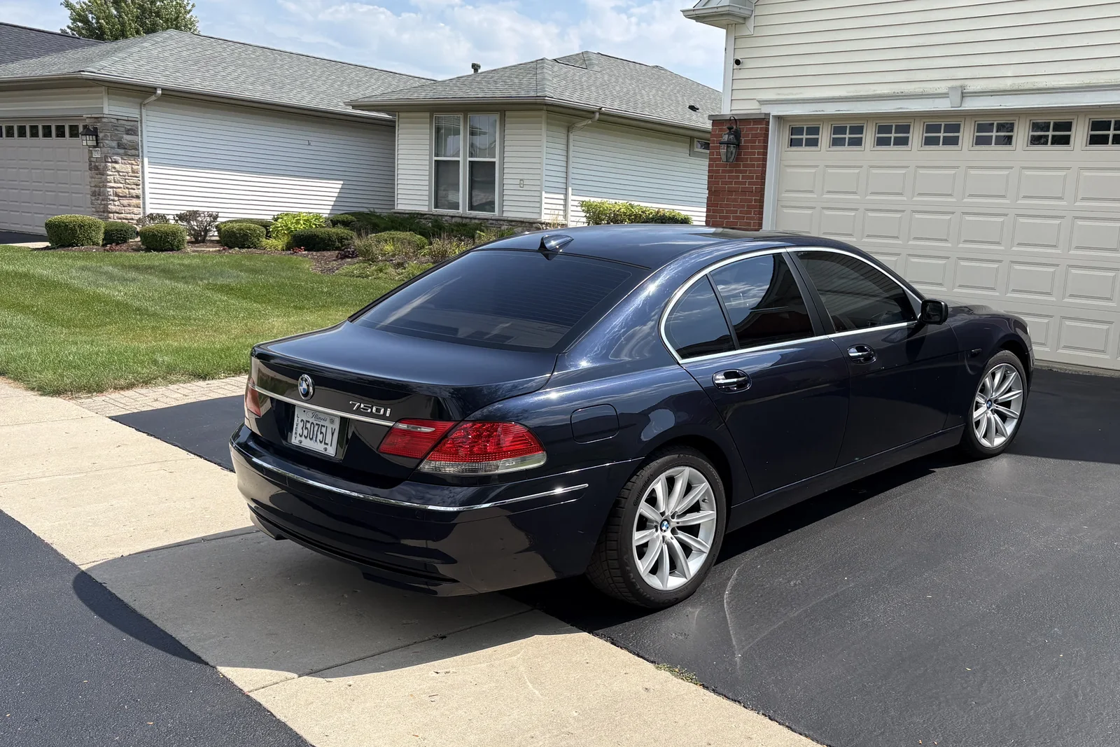 Cloud 9 black BMW 750i sedan, rear three-quarter view